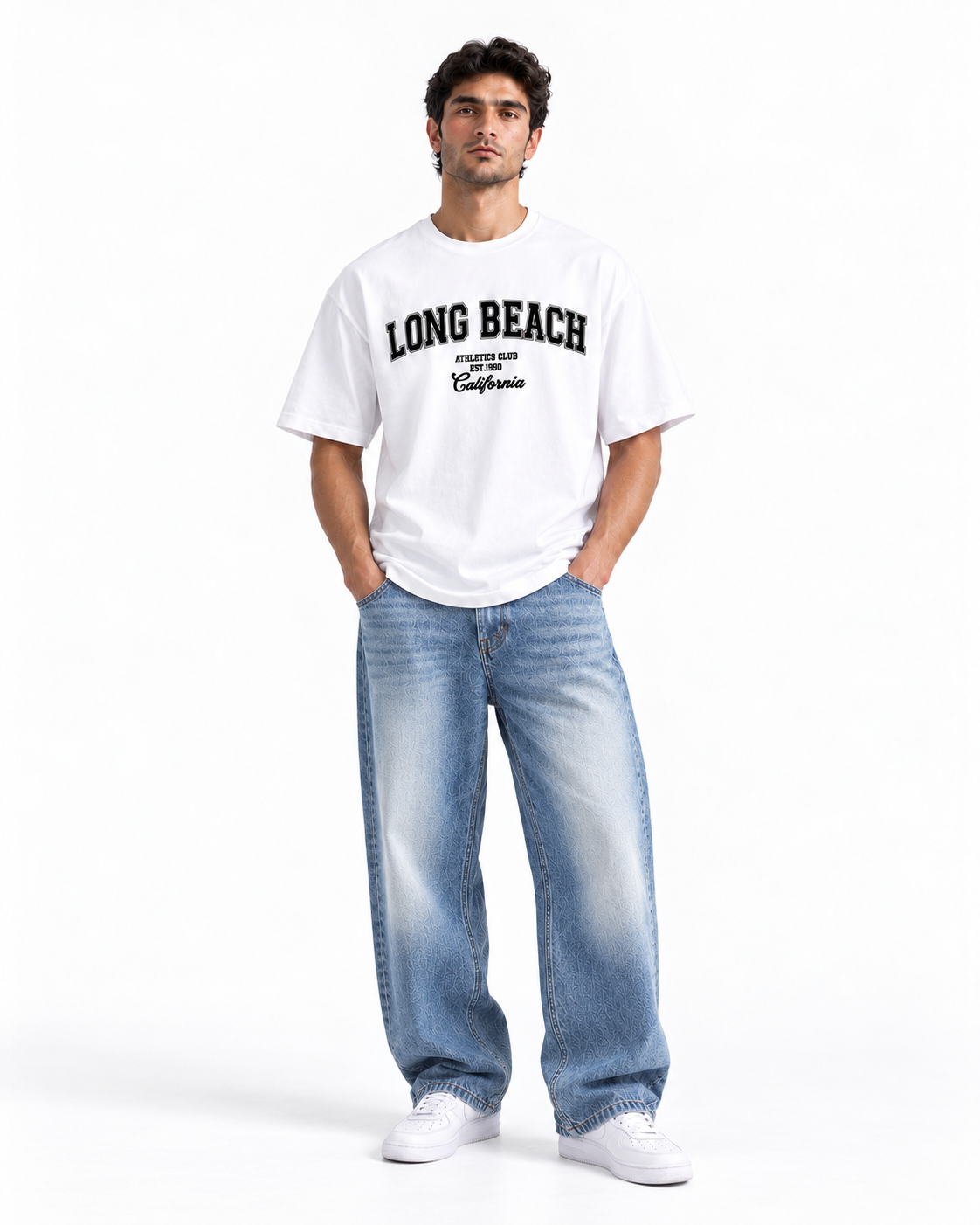 A man modeling a white crewneck t-shirt with 'LONG BEACH' printed in black varsity lettering, paired with light-wash blue jeans and white sneakers, against a plain white studio background.