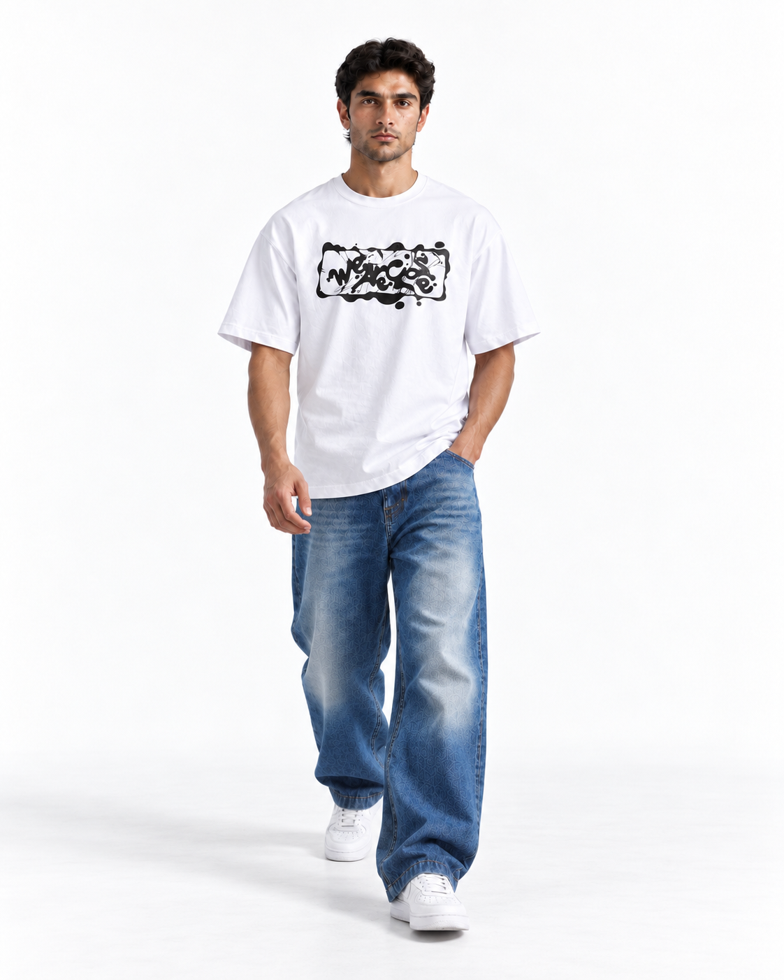 A man modeling a white short-sleeve t-shirt with a black graphic print on the chest, paired with wide-leg blue jeans and white sneakers, against a plain white studio background.