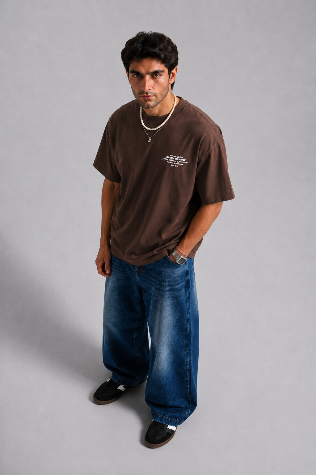 Model wearing brown oversized Unknown Paradise graphic T-shirt with baggy blue jeans