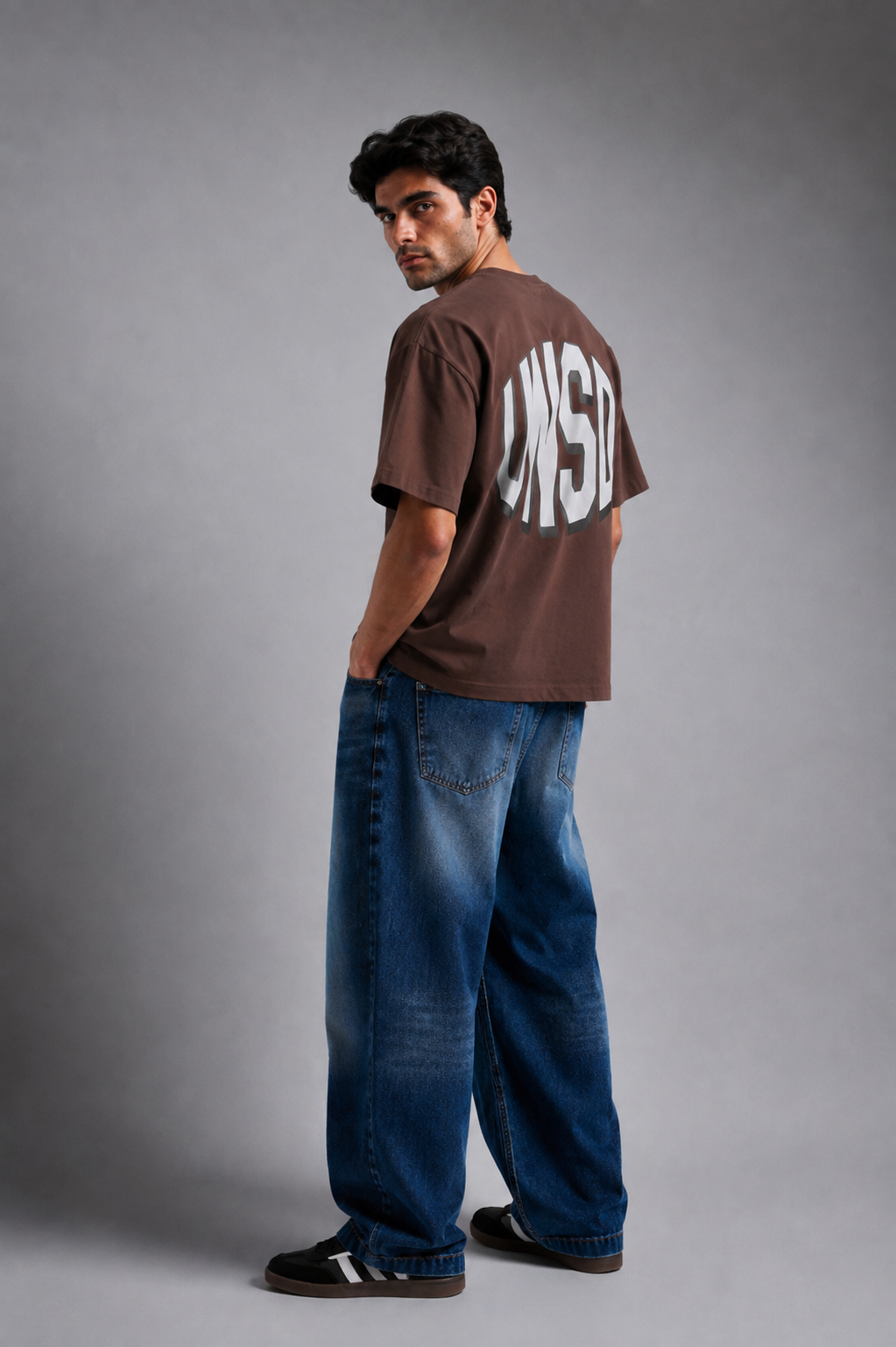Brown UNSTD graphic tee styled with baggy jeans