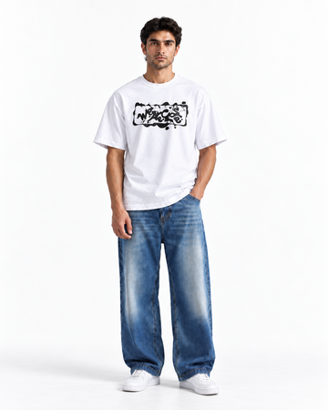 A man modeling a white short-sleeve t-shirt with a black graphic print on the chest, paired with wide-leg blue jeans and white sneakers, against a plain white studio background.